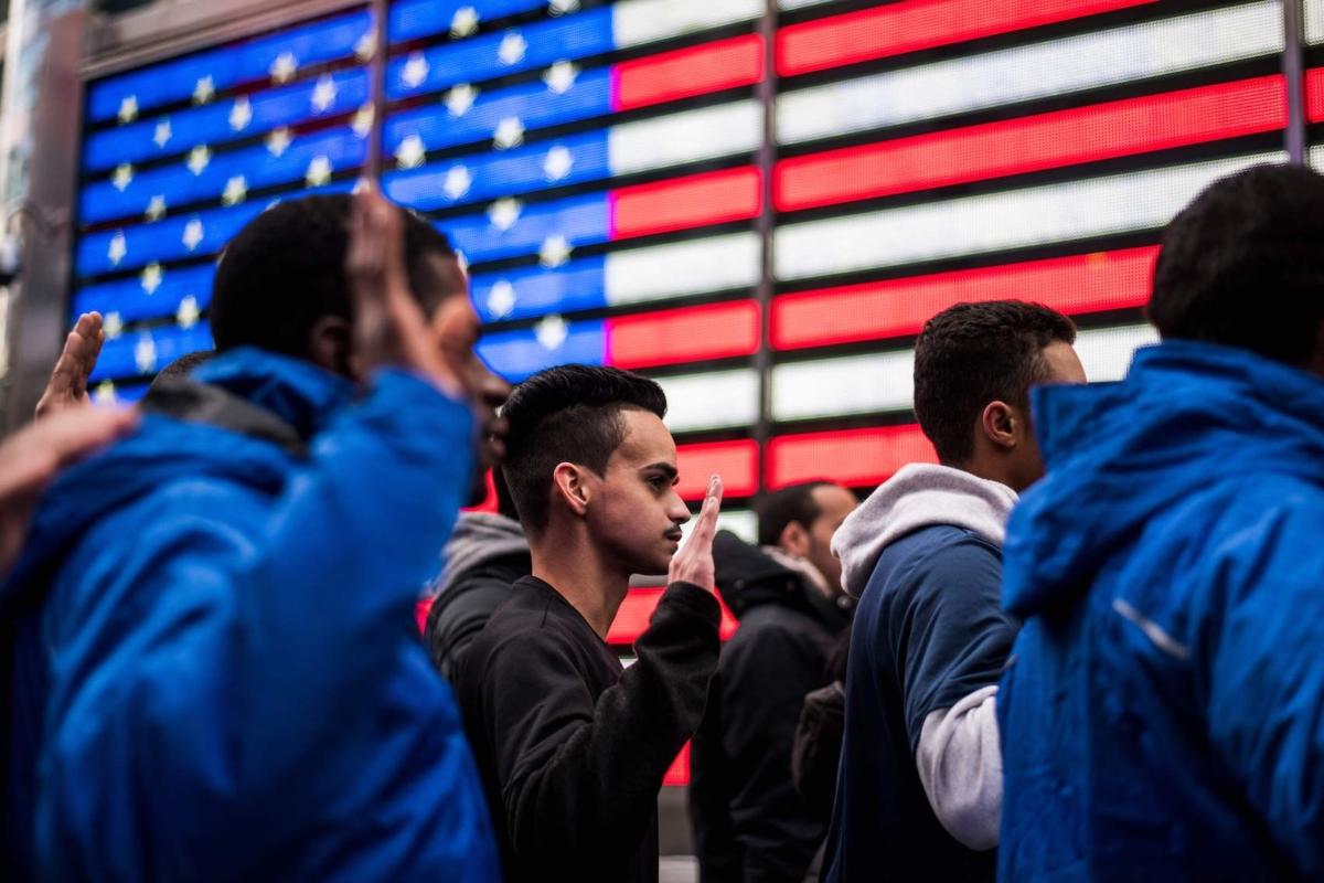 New recruits raise their hands as they take an oath outside the Times Square Military Recruiting Station in New York on Nov. 10, 2017. (Jewel Samad/AFP via Getty Images)