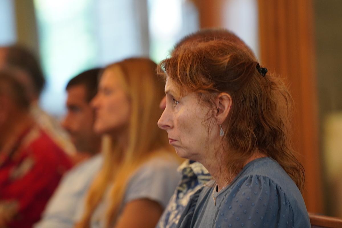 A grieving woman listens to a sermon at Kihei Baptist Church on Maui on Aug. 13, 2023. (Allan Stein/The Epoch Times)