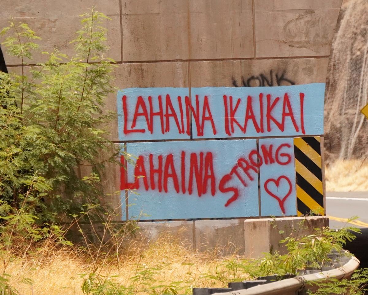 A sign made with spray paint seeks to inspire motorists on Route 30 heading into the fire-ravaged town of Lahaina, Maui, on Aug. 16, 2023. (Allan Stein/The Epoch Times)