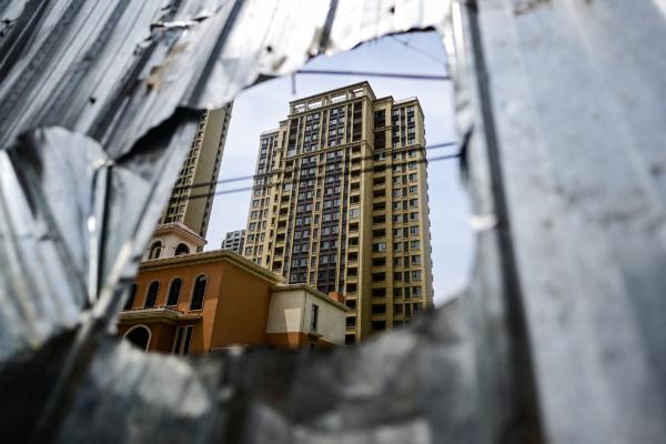 2023年6月20日，中部河南省鄭州市轄區的新鄭市，人們看到一片未完工的住宅小區樓群。（Pedro Pardo/AFP via Getty Images）