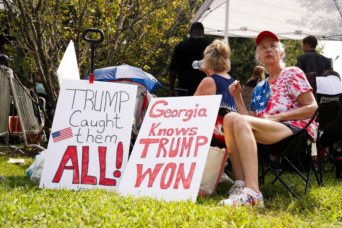 Protestors hold banners at the Fulton County Jail in Atlanta, Ga., on Aug. 24, 2023. (Madalina Vasiliu/The Epoch Times)