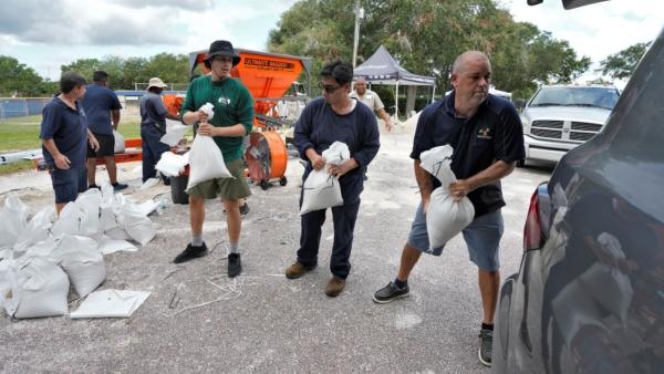Members of the Tampa, Fla., Parks and Recreation Dept., help residents load sandbags in Tampa, Fla., on Aug. 28, 2023. (Chris O'Meara/AP Photo)