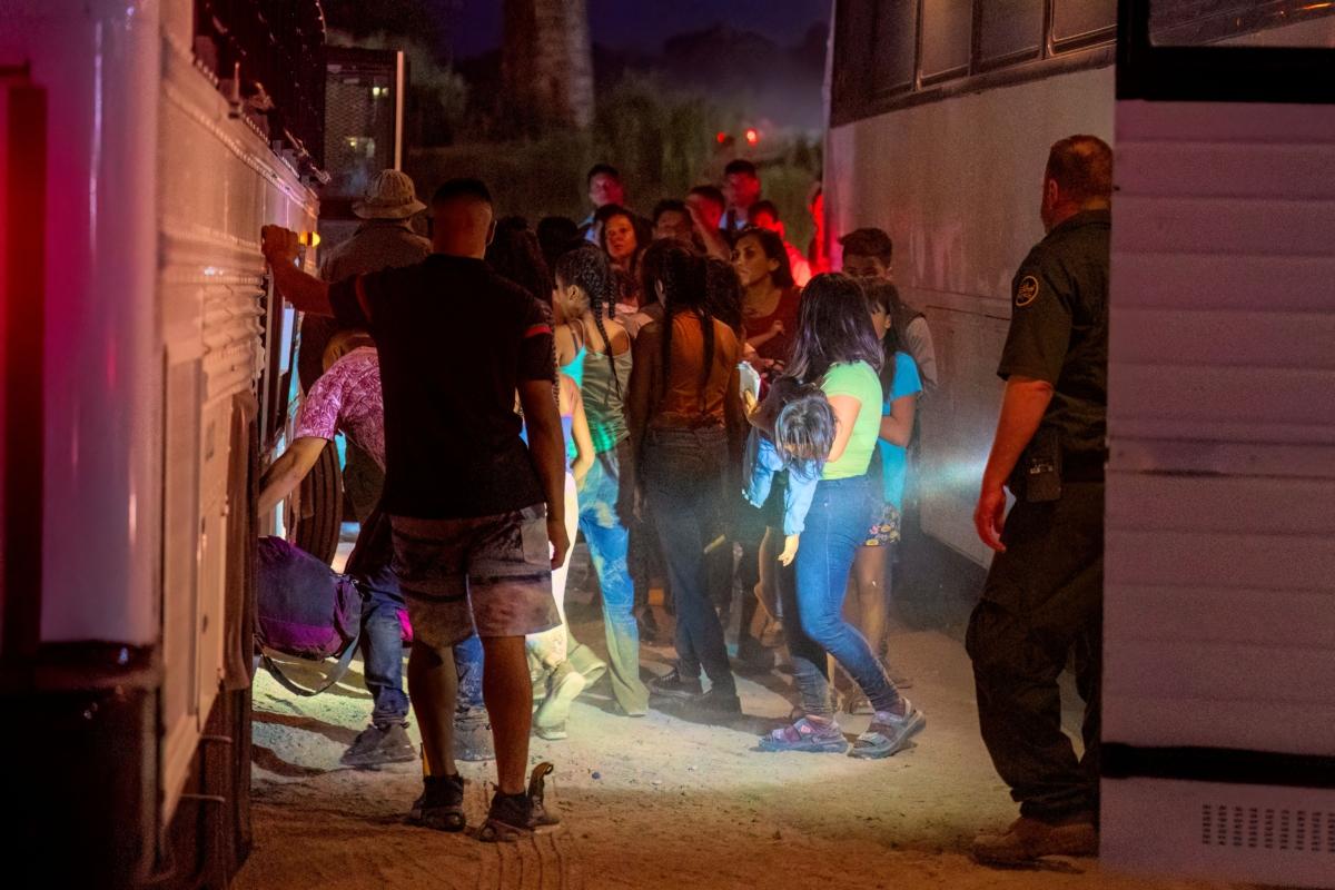 Border Patrol agents escort illegal immigrants onto a bus to be taken to a processing facility in Eagle Pass, Texas, on June 25, 2023. (Suzanne Cordeiro/AFP via Getty Images)