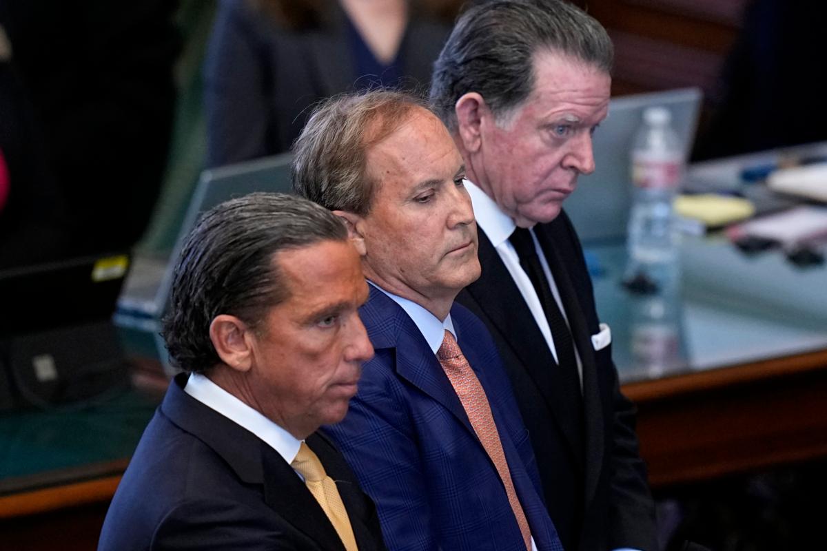 Texas state Attorney General Ken Paxton (C) stands between his attorneys Tony Buzbee (front) and Dan Cogdell as the articles of his impeachment are read during his impeachment trial in the Senate Chamber at the Texas Capitol in Austin on Sept. 5, 2023. (Eric Gay/AP Photo)