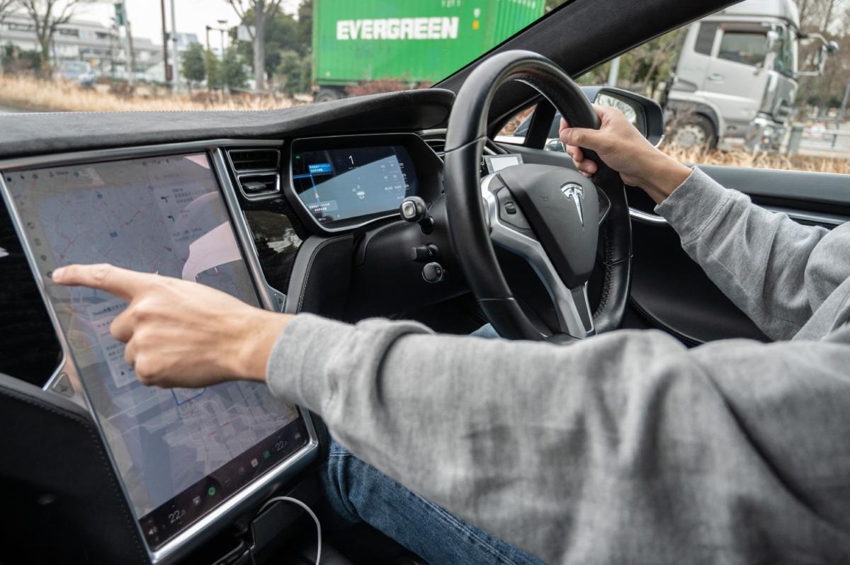 Atsushi Ikeda, the founder and vice president of a Japanese club for Tesla owners, operating a touchscreen display on the dashboard of his Tesla Model S in Tokyo on Jan. 27, 2023. (Yuichi Yamazaki/AFP via Getty Images)