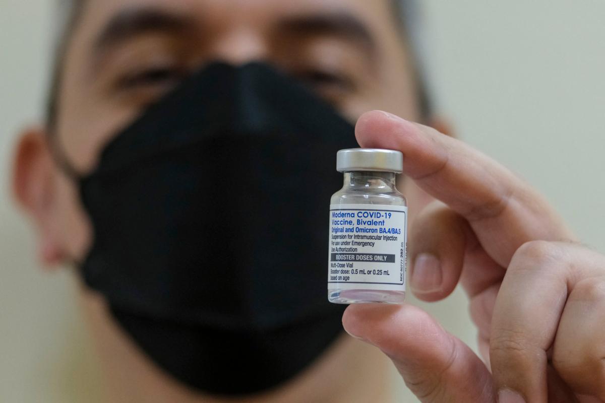 Un pharmacien présente un flacon du vaccin bivalent Moderna COVID-19 sur cette image.