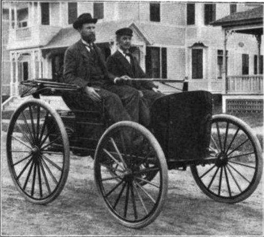 Charles (L) and J. Frank Duryea in the 1894 Duryea gasoline car, 1908. From "The Growth of the Automobile Industry in America," author unknown, in The Outing Magazine. (Public Domain)