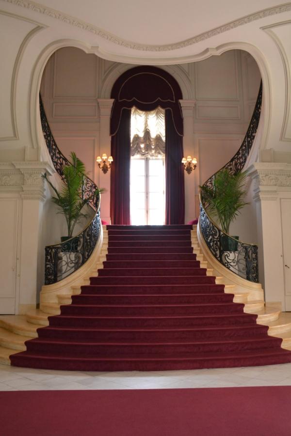 Made of Caen limestone, a cream-colored stone quarried near Caen, France, Rosecliff’s signature heart-shaped staircase is most likely modeled after a similarly designed staircase in Nancy, France. The lush red velvet drapes and red carpet dramatize the heart-shaped design, while the wrought-iron stair railings add additional décor to the already distinct display. (Courtesy of The Preservation Society of Newport County)