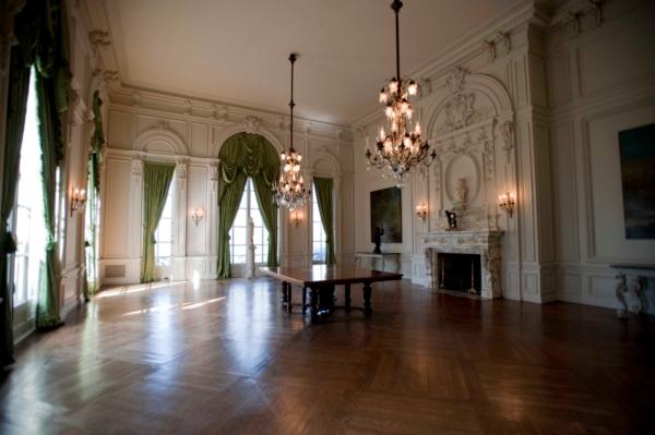 The pea-green, heavily draped spacious dining room was, in the early 1900s, the scene of 200-seat elaborate, seven-course dinners as well as costume balls. Like the mansion’s ballroom, the flooring is oak and the focal points are the numerous moldings as well as the marble fireplace mantel and intricately designed chandeliers. (Courtesy of The Preservation Society of Newport County)