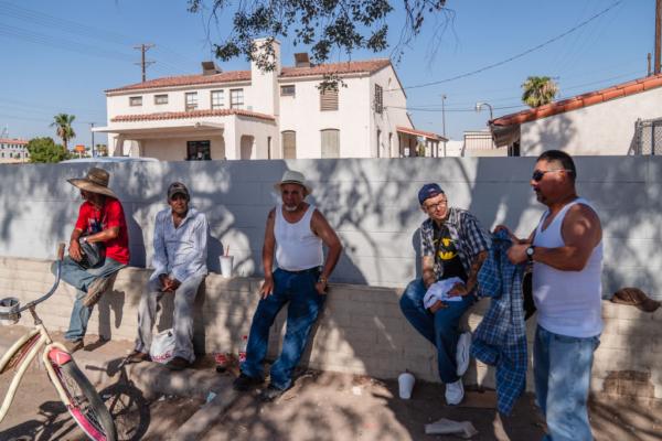 A group of men sit underneath a tree for shade amid a heatwave in Calexico, Calif., on Aug. 31, 2022. (Ariana Drehsler/Getty Images)