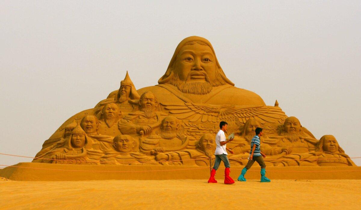 Tourists walk past a sand sculpture of Genghis Khan as they tour the Xiangshawan, also called Resonant Sand Bay, in Baton, Inner Mongolia, on July 16, 2007. (China Photos/Getty Images)