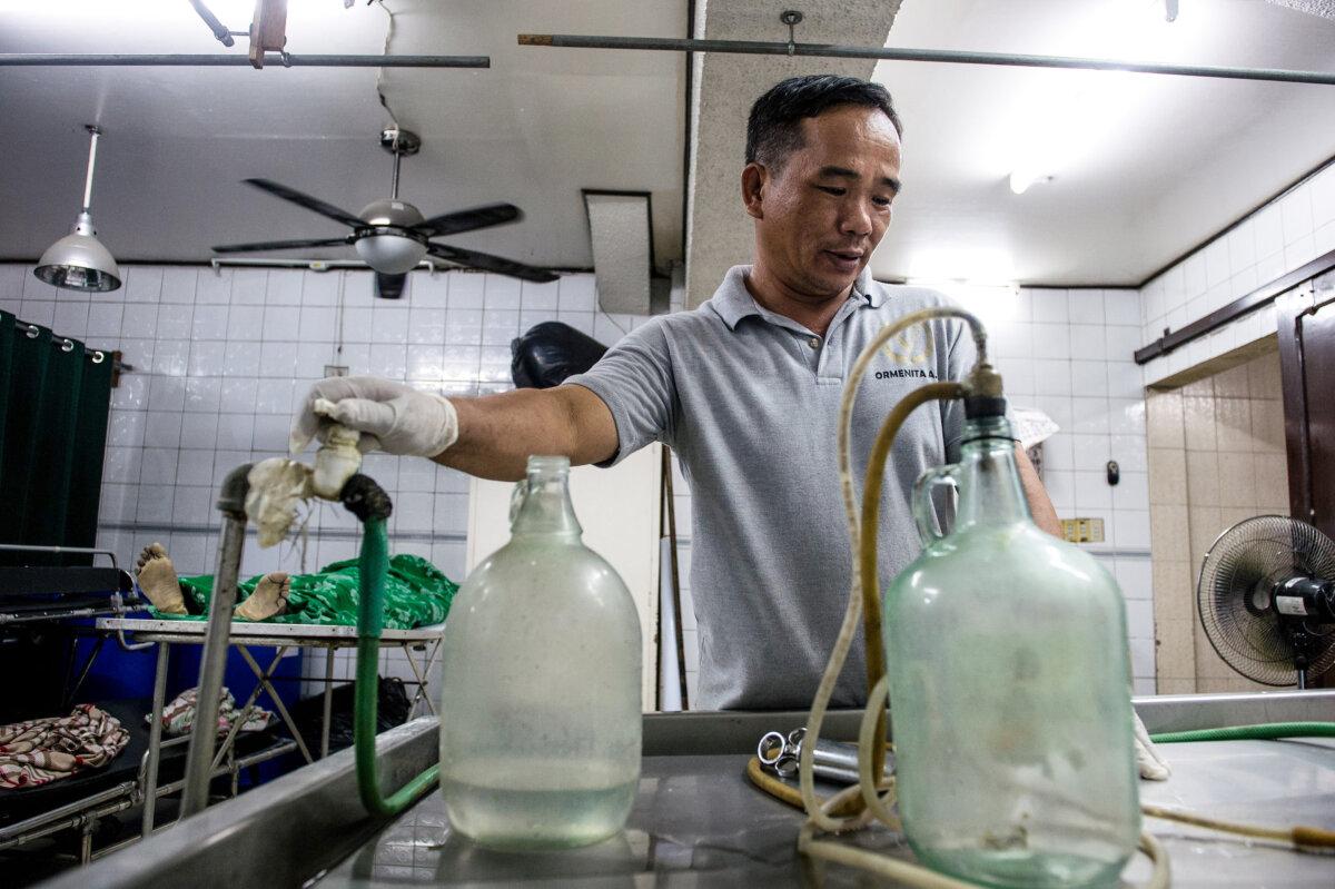 An embalmer prepares embalming instruments before operating on a body, inside the morgue of Veronica Memorial Chapel in Manila, Philippines, on Oct. 30, 2016. (Noel Celis/AFP via Getty Images)