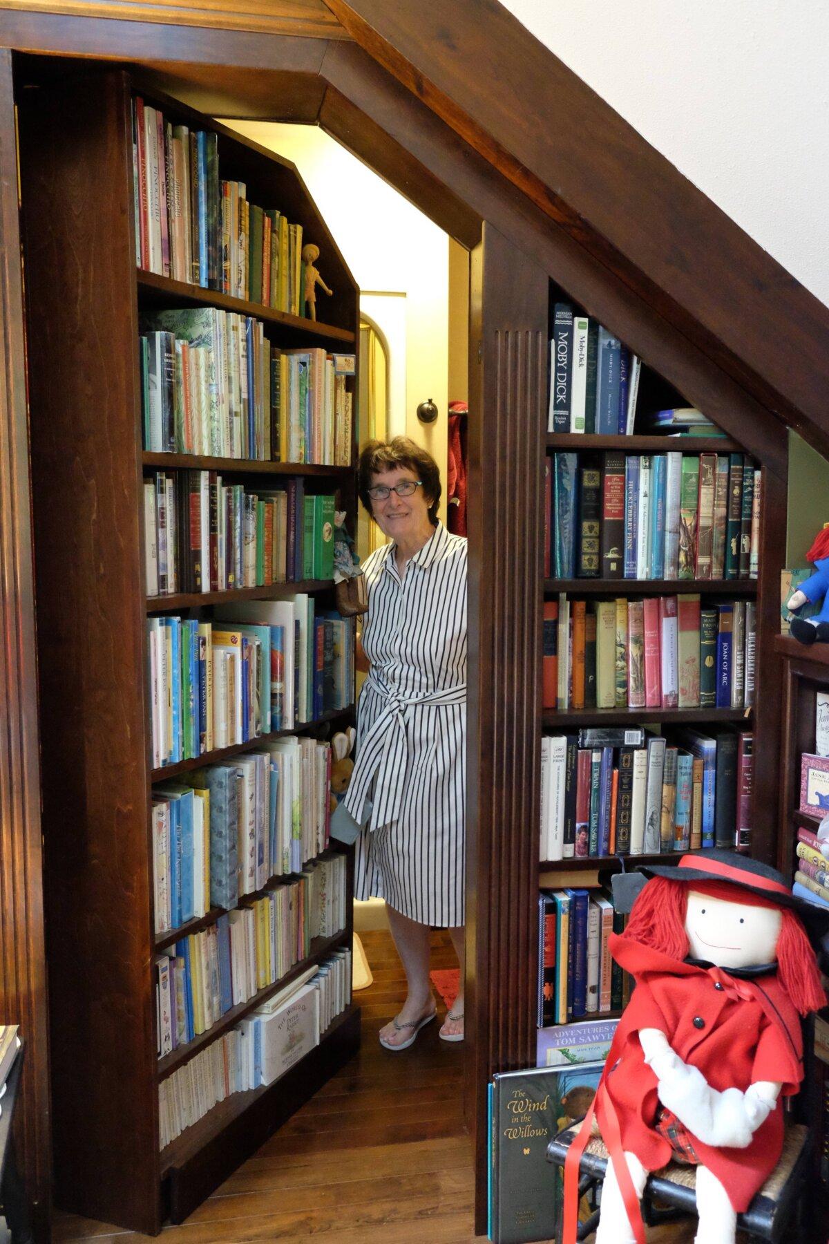 Mrs. Anderson demonstrates the swinging bookcase door in her library’s loft. (Annie Holmquist)