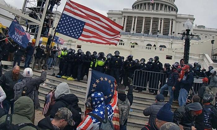 Samuel Lazar, 37, of Ephrata, Pa., gives a middle-finger salute to the police line on the U.S. Capitol's west plaza on Jan. 6, 2021. (Special to The Epoch Times)