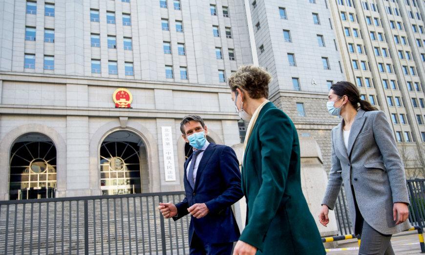 Australian Embassy staff walk in front of the Beijing No. 2 People's Intermediate Court, where Australian journalist Cheng Lei faces trial after 18 months in detention on charges of supplying state secrets, on March 31, 2022. (Noel Celis/AFP via Getty Images)