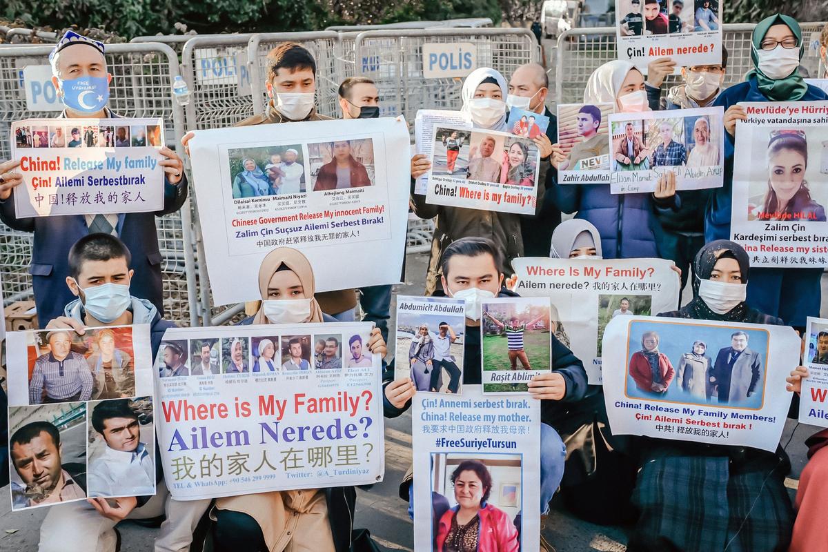 Members of the Muslim Uyghur minority hold placards as they demonstrate in front of the Chinese consulate on Dec. 30, 2020, in Istanbul, to ask for news of their relatives and to express their concern after China announced the ratification of an extradition treaty with Turkey. (Bulent Kilic/AFP via Getty Images)