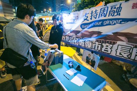 People drop in their support in a mock booth in the Central District designed to look like the Anti-occupy booth that has been around the Hong Kong area on Nov. 3, 2014. (Benjamin Chasteen/Epoch Times)