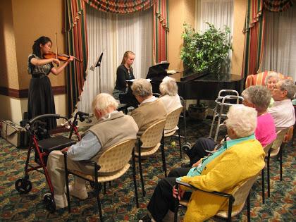 Musicians With a Mission violinist and pianist at Weinberg Terrace, a senior living facility, in Pittsburgh. (Courtesy of Devin Arrington)