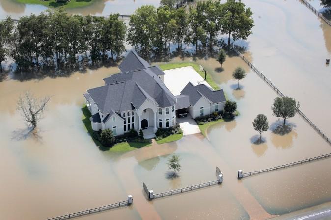 A mansion surrounded by flood water after torrential rains pounded Southeast Texas is seen on August 31, 2017, near Sugar Land, Texas. While tempting for looters, law enforcement agencies are pledging increased penalties and determined prosecutions for crimes like looting and burglary committed in the wake of Hurricane Harvey. (Scott Olson/Getty Images)