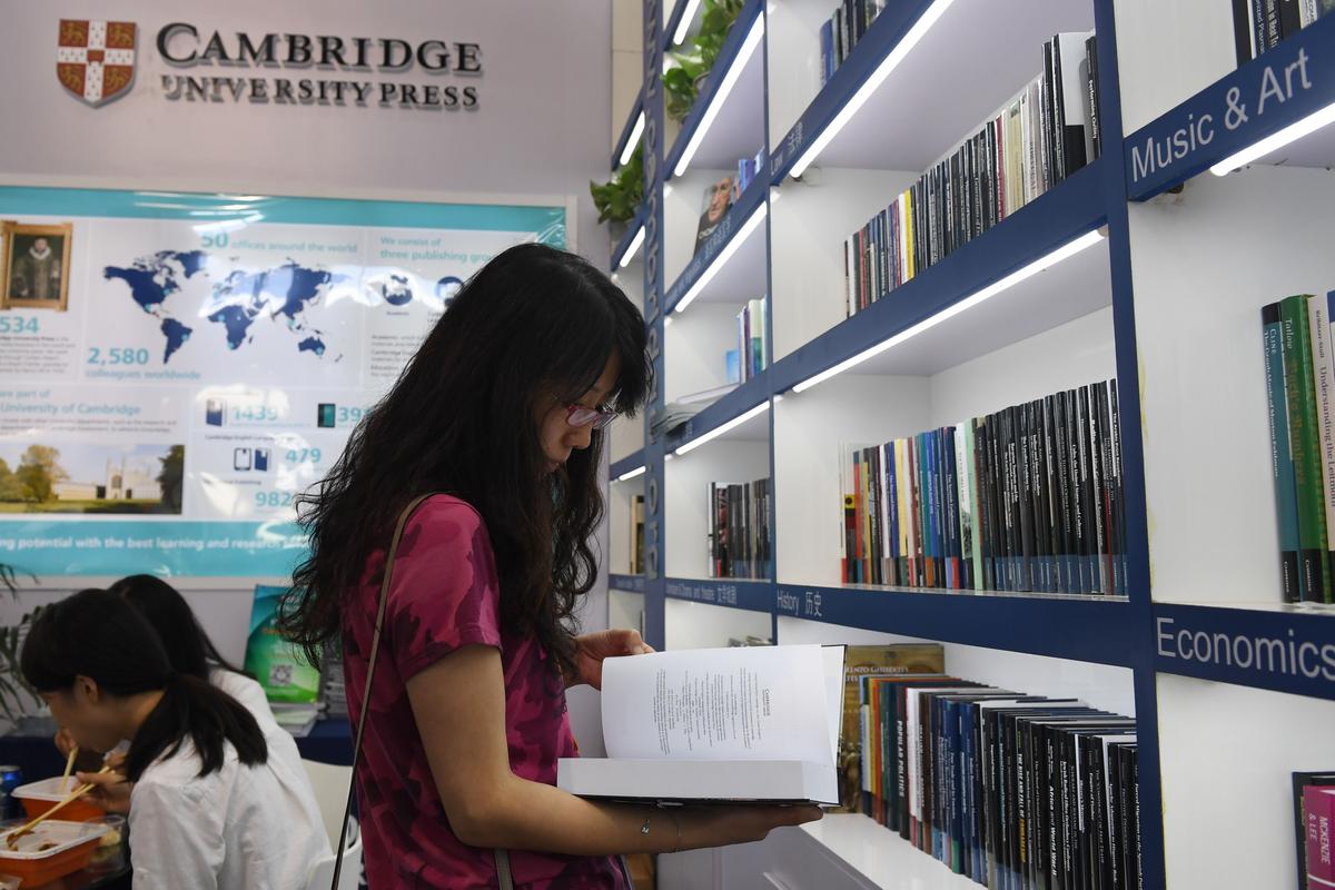 This photo taken on August 23, 2017 shows a woman reading a book at the Cambridge University Press stand at the Beijing International Book Fair in Beijing. (GREG BAKER/AFP/Getty Images)