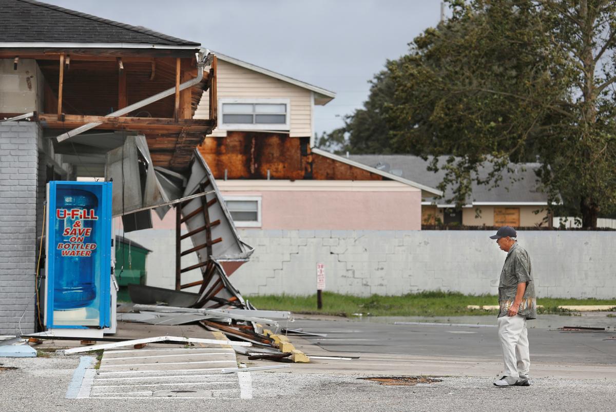 A local resident observes the remains of a Sunoco gas station in the wake of Hurricane Irma in Kissimmee, Florida on Sept. 11, 2017. (REUTERS/Gregg Newton)