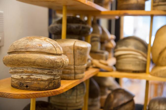 Antique wooden hat blocks, used to shape hats, line the shelves at the Jennifer Ouellette studio. (Benjamin Chasteen/The Epoch Times)
