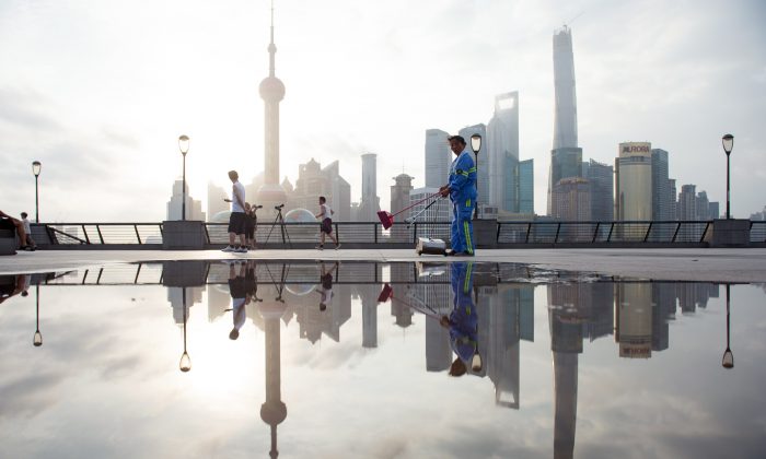 A worker cleans the promenade in Shanghai on July 24, 2014. (Johannes Eisele/AFP/Getty Images)