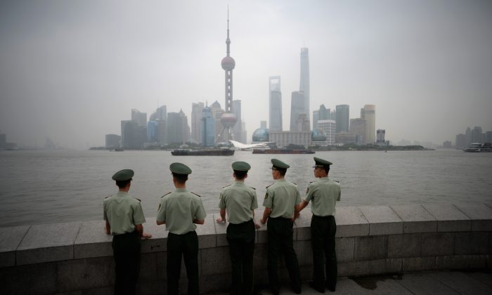 Paramilitary policemen stand in front of the skyline of the Lujiazui Financial District in Pudong in smog in Shanghai. (Johannes Eisele/AFP/Getty Images)
