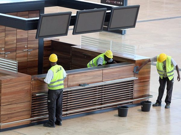 Workers clean a check-in counter at the construction site of the Berlin Brandenburg Airport (BER) in Berlin on Sept. 11, 2012. The airport is only one of several stalled major building projects in Germany that have exceeded cost and time estimates. (Adam Berry/Getty Images)