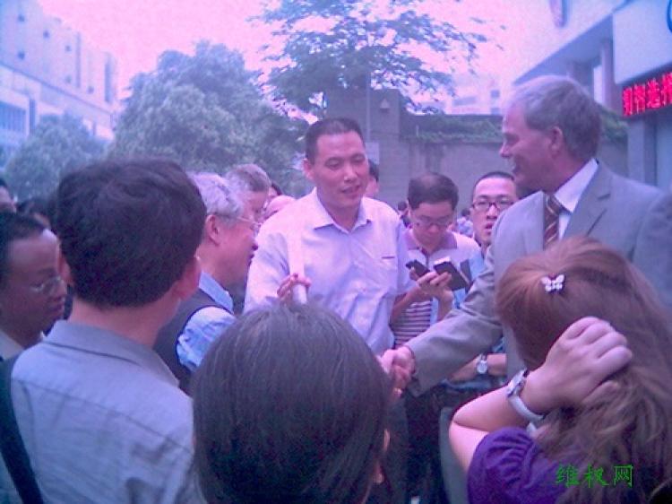 Defense attorney Pu Zhiqiang interviewed by foreign media outside the Chengdu Municipal Intermediate Peoples Court . A German Consulate staff member is also present. (Courtesy of Chinese Human Rights Defenders)