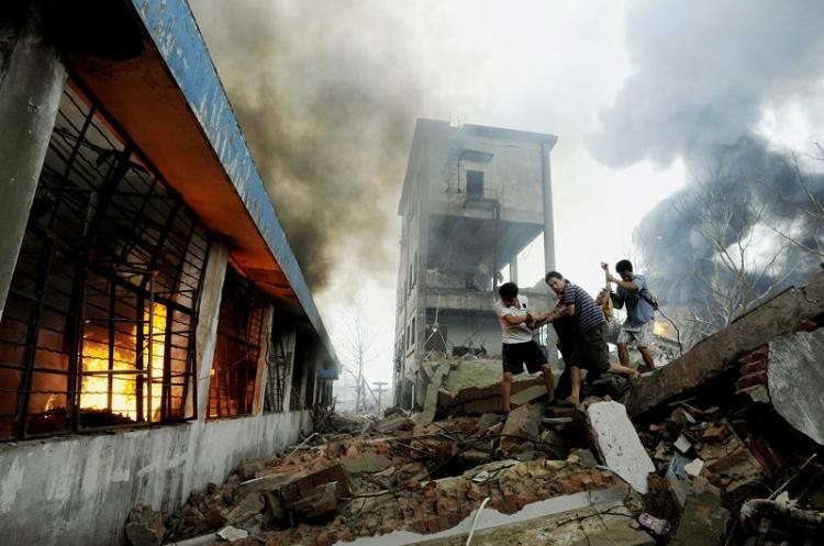 People carry a wounded man from the site of an explosion at a plastics factory in Nanjing, east China's Jiangsu Province on July 28, 2010. (AFP/Getty Images)