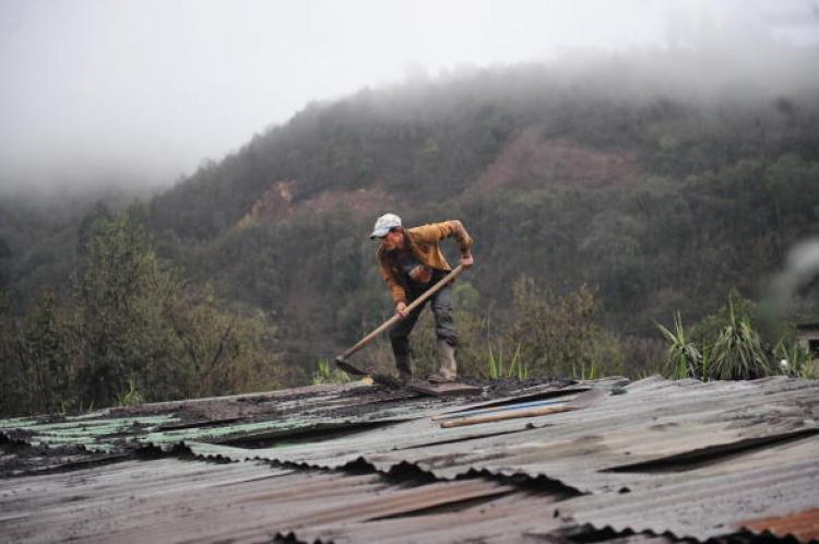 A man cleans the roof of his home of ashes from the Pacaya volcano, some 50 km (31 miles) south of Guatemala City, in Las Calderas, San Vicente Pacaya, Guatemala.  (Johan Ordonez/Getty Images)