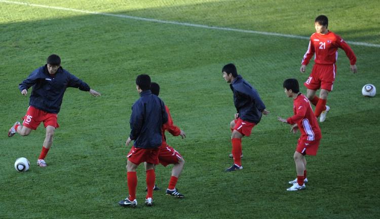 North Korea's midfielder Kim Yong-Jun (L) kicks the ball to his teammates as they warm up during a training session at the Makhulong Stadium on June 8, 2010 in Tembisa ahead of the 2010 World Cup which takes place in South Africa between June 11 and July 11. (Stephane de Sakutin/AFP/Getty Images)