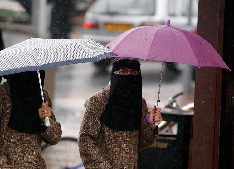 Women, sheltering under umbrellas, wear full face Niqab on the streets of Blackburn July 20, 2010 in Blackburn, England. (Christopher Furlong/Getty Images)