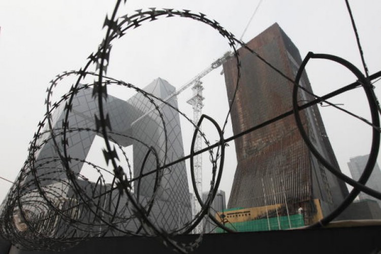 The China Central Television (CCTV) complex is pictured behind a barbed-wire fence in Beijing on Aug. 13, 2010.  (Lee/AFP/Getty Images)