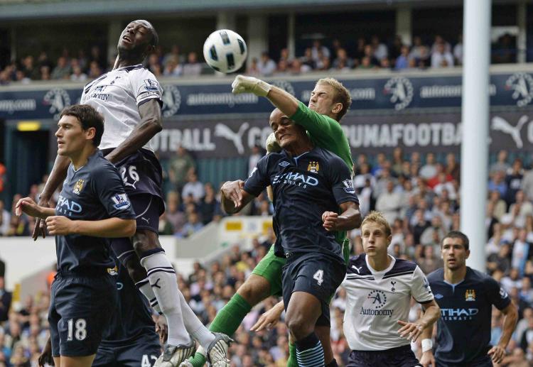 HEAT OF THE BATTLE: Manchester City's Joe Hart (green) punches away a Tottenham cross in Saturday's English Premier League opener. (Ian Kington/AFP/Getty Images)