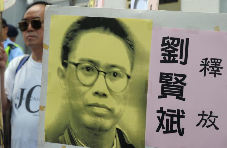 Liu Xianbin larger than life on a placard in Hong Kong. Supporters protest his detention on Aug. 27, 2010. (Mike Clarke/AFP/Getty Images)