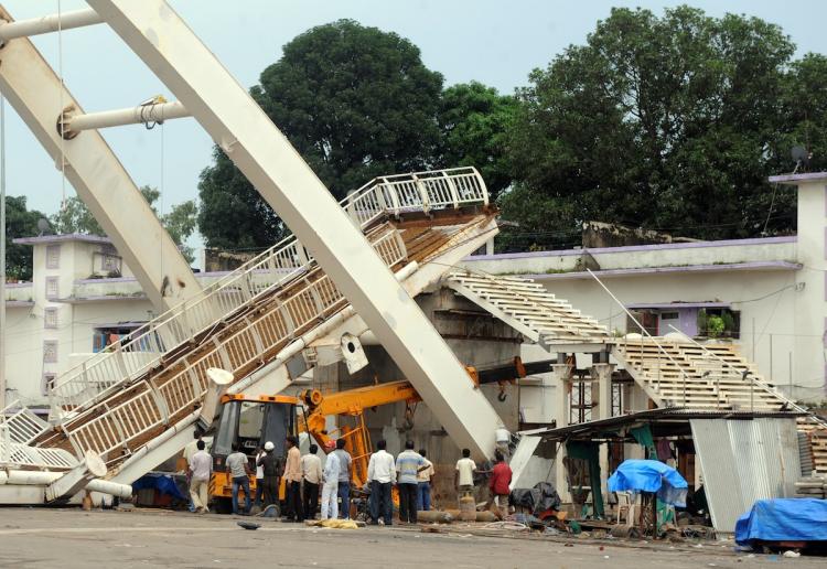COLLAPSE: Indian workers gather after a collapsed footbridge at the Jawaharlal Stadium in New Delhi on Sept. 21, the main venue for the forthcoming Commonwealth Games. The games are set to begin Oct. 3.  (Raveendran/Getty Images )
