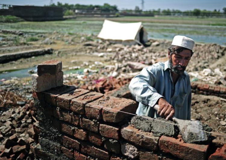 A Pakistani man begins to rebuild his home in Nowshera on September 21. United Nation aid agencies have warned that flood stricken areas of Pakistan face a looming threat of child malnutrition.  (Carl de Souza/Getty Images )