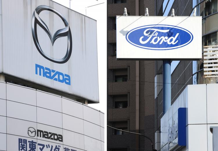 Mazda and Ford motors logos displayed at their respective car dealerships in Tokyo on October 16. Ford Motor Co., said that it is cutting its ownership stake in Japanese automaker Mazda Motor Corp. to 3.5 percent.   (Toshifumi Kitamura/Getty Images)