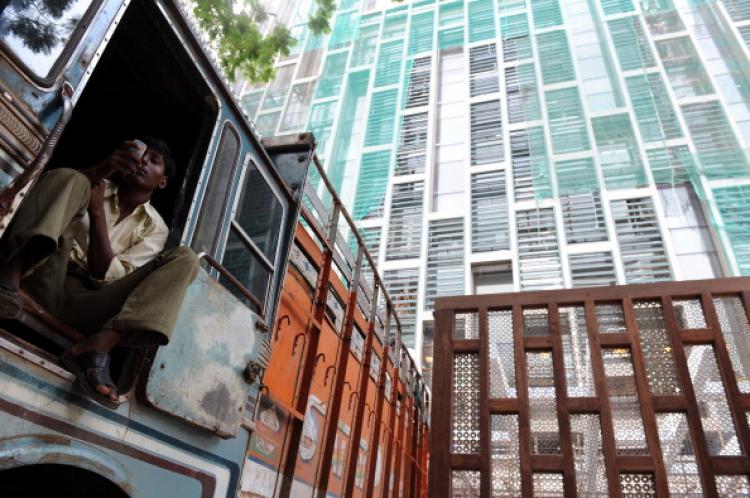 A worker checks his mobile phone, at the entrance of the twenty-seven storey Antilia, the newly-built residence. (Indranil Mukherjee/AFP/Getty Images)