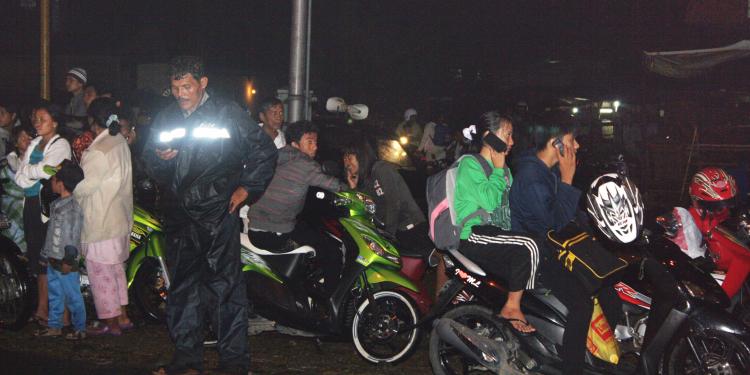 People try to reach their relatives by cellular phone as they flee to higher ground in Padang, West Sumatra, on Oct. 25 after a major 7.5-magnitude earthquake triggered a tsunami warning. (Rus Akbar/AFP/Getty Images)