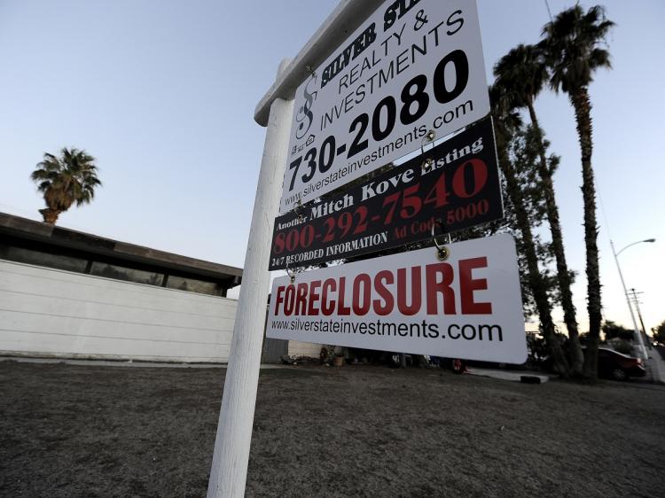 NO 'ROBO-SIGNING': A Foreclosure sign is seen in front of a bank-owned home in Las Vegas, Nev., Nov. 8. All 50 states have unveiled a joint investigation into banks and mortgage companies that repossessed homes in the wake of the financial crisis.  (Robyn Beck/AFP/Getty Images)