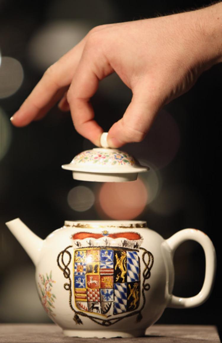 A Bonhams employee lifts the lid on a porcelain teapot dated 1713-14, at Bonhams Auction house on November 22, 2010 in London, England.  ( Dan Kitwood/Getty Images)