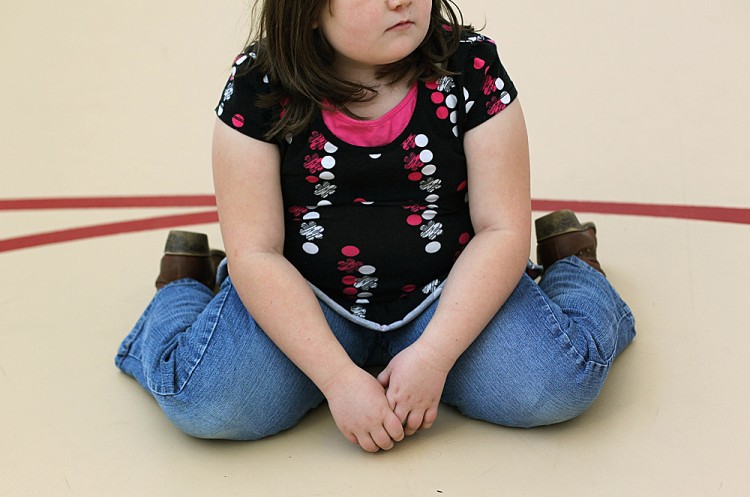 A child sits on the gym floor during a workout. (John Moore/Getty Images)