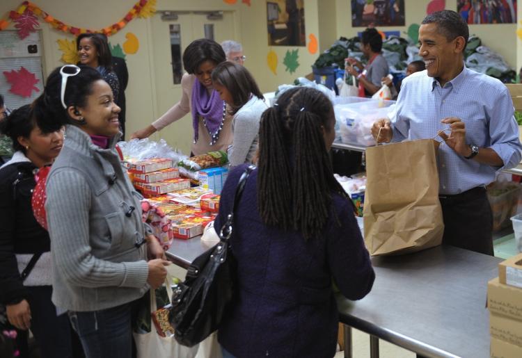 US President Obama smiles while distributing food at Martha's Table a day before Thanksgiving, on November 24, in Washington, DC. Martha's Table is a non-profit organization that provides food, shelter and clothing to those in need.  (Mandel NGAN/Getty Images )