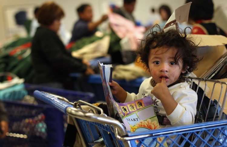 A child waits as his mother joins fellow low-income shoppers searching bins for toys at a Goodwill thrift store on Black Friday, November 26, 2010 in Denver, Colorado. (John Moore/Getty Images)