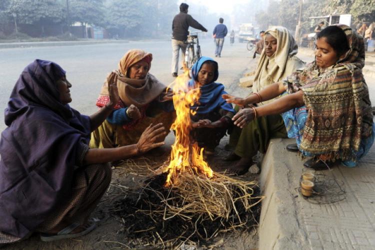 Indian street sweepers warm themselves as they sit around a bonfire on a roadside in Amritsar on Dec. 3, 2010. (Narinder Nanu/AFP/Getty Images)