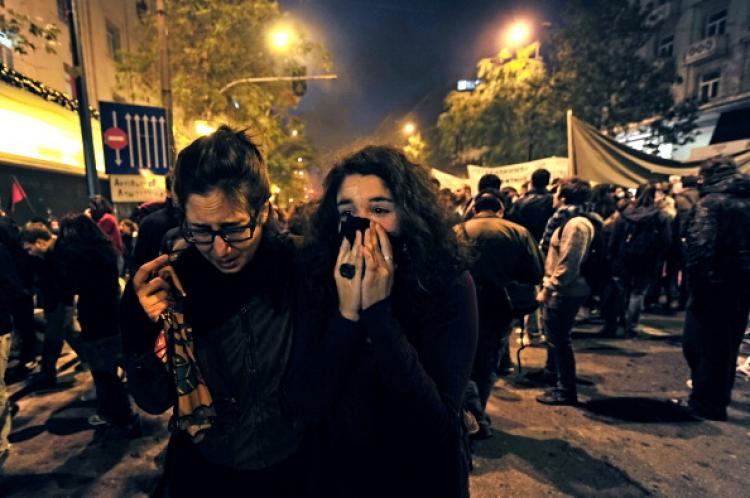 Demonstrators protect their faces from tear gas in the center of Athens on Dec. 6, 2010. (Aris MessInis/AFP/Getty Images) Demonstrators protect their faces from tear gas in the center of Athens on Dec. 6, 2010. (Aris MessInis/AFP/Getty Images)