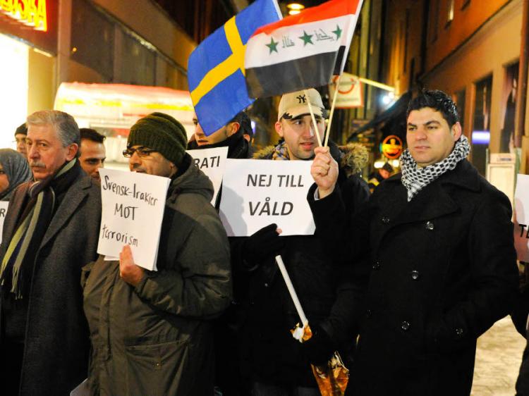 ANTI-VIOLENCE: Demonstrators are flying both the Swedish and the Iraqi flags in a show against violence, held at the site of Saturday's suicide bombing in Stockholm, Stockholm, Dec. 13. (Epoch Times Staff)